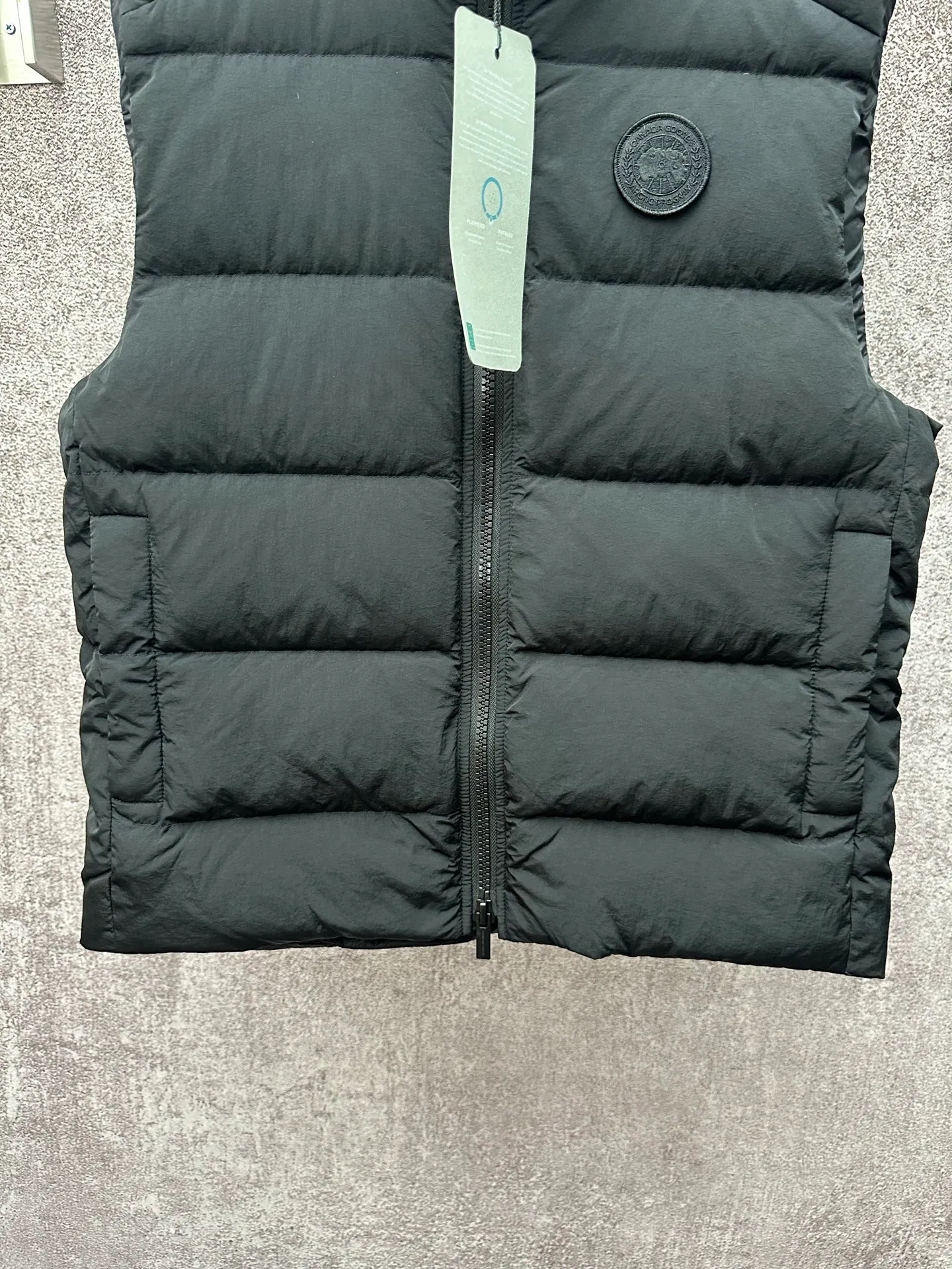 P720 Canada Goose Badge Down Vest Fabric selection: The use of high-quality protective nylon fabric not only enhances the wear resistance of the surface, but also takes into account wind resistance, ensuring excellent performance in various harsh weather conditions.  90 national standard high-quality white duck down: selected high-loft down, weighing 160g, light and warm, with excellent temperature locking performance and good resilience.  Three-dimensional quilting process: Precision thread reinforcement to prevent velvet drilling and ensure that the fluffy and resilient elasticity lasts as new.  Details: The ribbon is woven with polyester as the base, and the brand letters are decorated on the ribbon through high-precision computer embroidery. The edges of the pattern are clear, the stitches are fine and even, and multiple layers of embroidery thread are stacked to enhance the three-dimensional effect. Accessories: One-to-one customized logo, one-to-one customized zipper puller, one-to-one customized three-label SIZE: S M L XL